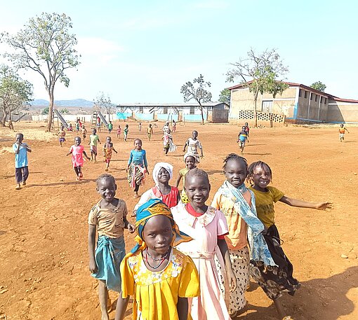 Geflüchtete Kinder in Ura, Äthiopien, die mit Freude auf die Betrachter:in zugelaufen kommen.