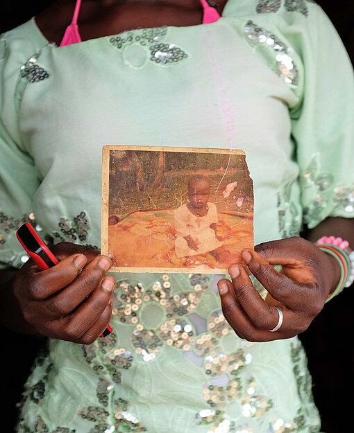 Eine Frau zeigt das Foto ihrer kleinen Tochter