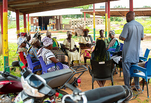 Die Königinnenmütter sitzen draußen in ihrer Gemeinde und reden