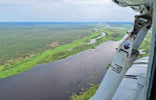 Der Weiße Nil ist 2024 in Südsudan vielerorts über die Ufer getreten und hat Ernten zerstört Aus dem Fenster eines Hubschraubers fällt der Blick auf eine flache, üppig grüne Flusslandschaft