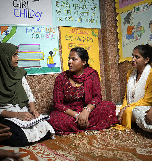 In der Jugendgruppe in Delhi trifft sich Afsana regelmäßig mit Gleichaltrigen, um sich auszutauschen Eine Gruppe junger Frauen aus Indien sitzt sich im Halbkreis auf dem Boden gegenüber und diskutiert angeregt