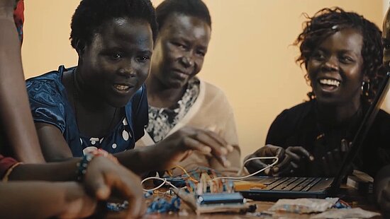 Vorschaubild für das Video: Eine Gruppe Schwarzer Mädchen sitzt vor einem Laptop.