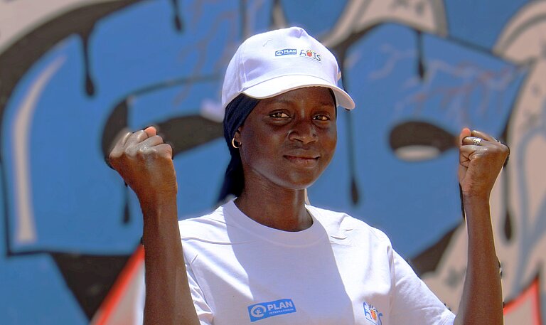 Fatou steht draußen in ihrer Gemeinde in Senegal 