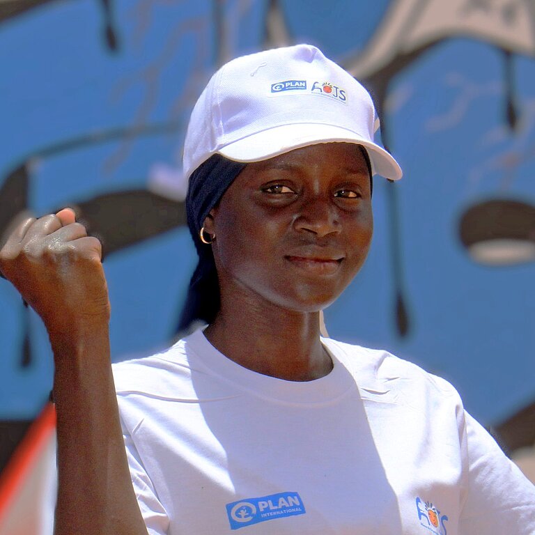 Fatou steht draußen in ihrer Gemeinde in Senegal 