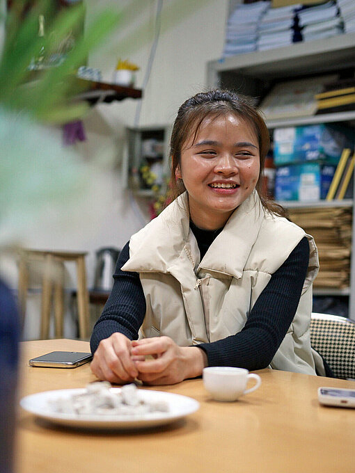 Kieu (19) absolviert in Hanoi ein Berufstraining im Tourismussektor Ein Mädchen sitzt am Schreibtisch