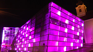Das Ars Electronica Center ist im Dunkeln Pink beleuchtet.