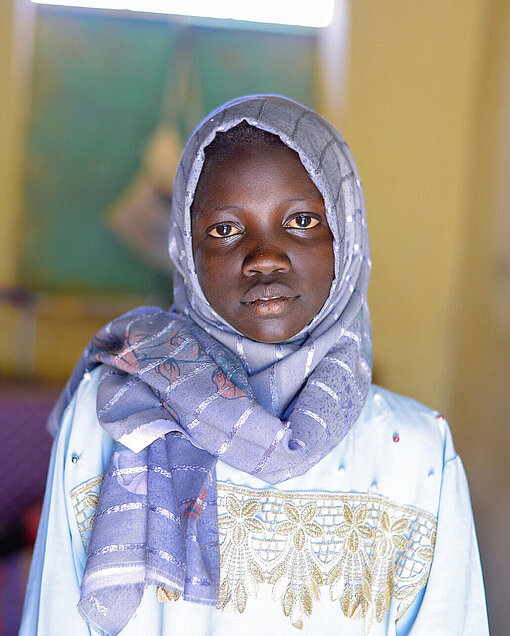 Muna (13) und ihre Freundinnen hoffen auf eine Waffenruhe in Sudan Ein Mädchen schaut in die Kamera