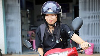 Eine Nahaufnahme von Kann auf ihrem roten Moped