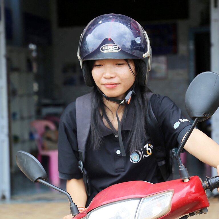 Eine Nahaufnahme von Kann auf ihrem roten Moped