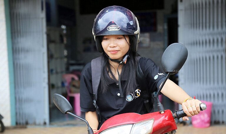 Eine Nahaufnahme von Kann auf ihrem roten Moped