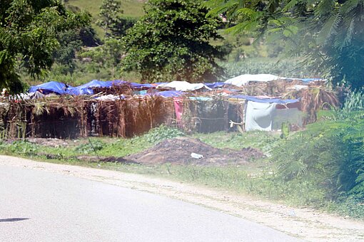 Joselines Notunterkunft liegt direkt an einer Hauptstraße – manchmal hat sie Angst, von den Autos überfahren zu werden. Notunterkunft in Haiti an einer Hauptstraße