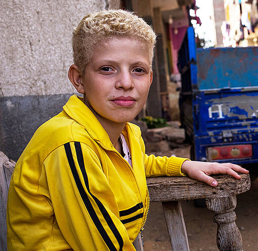 Mohamed in einer gelben Trainingsjacke auf der Straße.