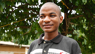 Ein blinder junger Mann im Porträt, er lächelt