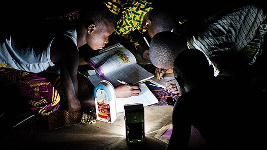 Im Schein der Taschenlampe erledigen Kinder ihre Hausaufgaben, weil es kein elektrisches Licht gibt.