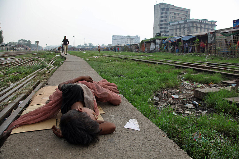 Ein Junge schläft an einem Bahngleis in der bangladeschischen Hauptstadt Dhaka
