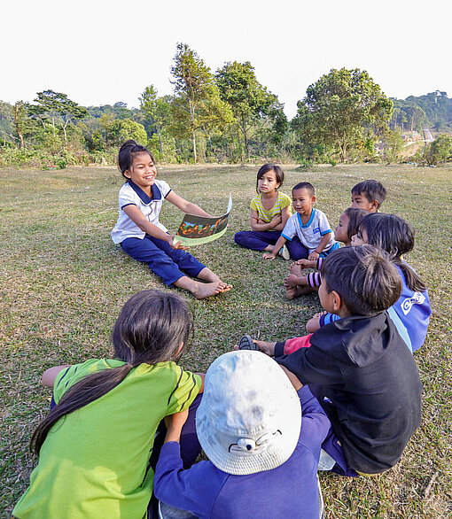 Kinder in einem Plan-Projekt in Vietnam lernen die Auswirkungen des Klimawandels kennen Kinder in Vietnam sitzen auf dem Boden