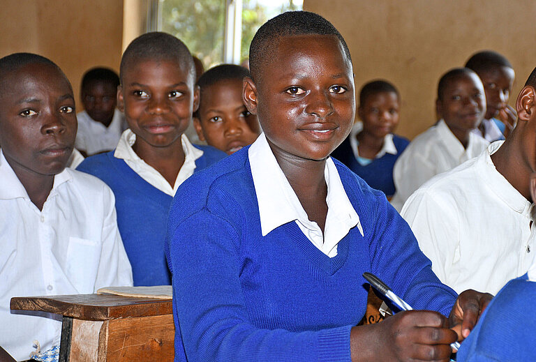 Hellen sitzt in einer Schulbank in Tansania