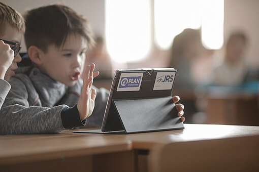 Zwei Jungen schauen auf einen Tablet-Computer