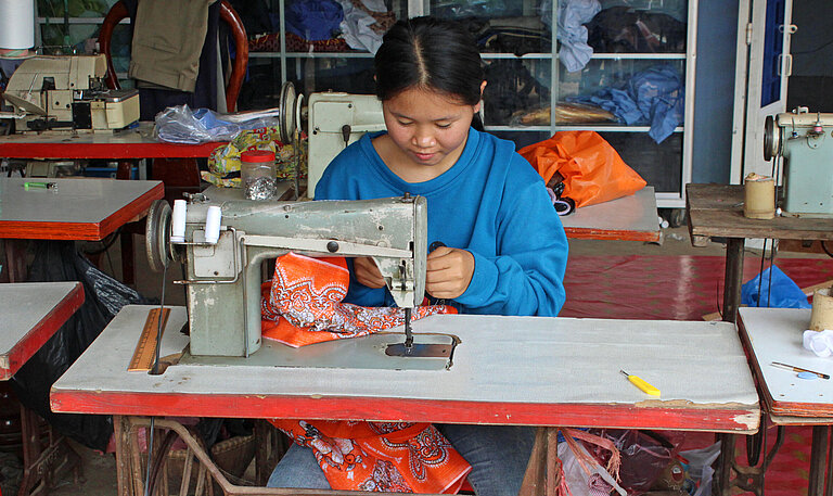 Junges Mädchen arbeitet an einer Nähmaschine