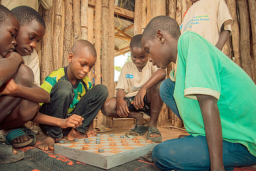 Kinder sitzen und spielen gemeinsam in einem geschützten Umfeld