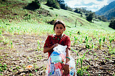 Ein Mädchen trägt ein Hygiene-Kit von Plan International