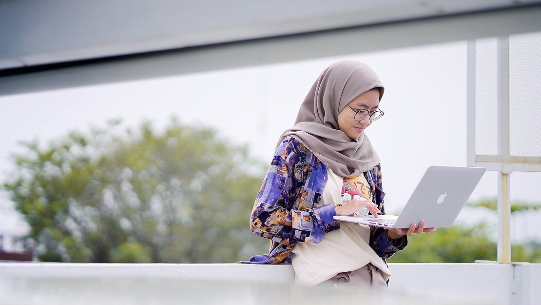Qonita hat erfolgreich am „Work in Tech“-Programm in Indonesien teilgenommen Eine junge Frau arbeitet am Laptop