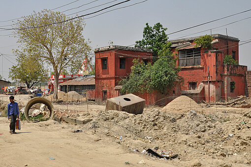 Janakpur Station: Ein Bahnhof ohne Gleise Rotes Gebäude in karger Umgebung.