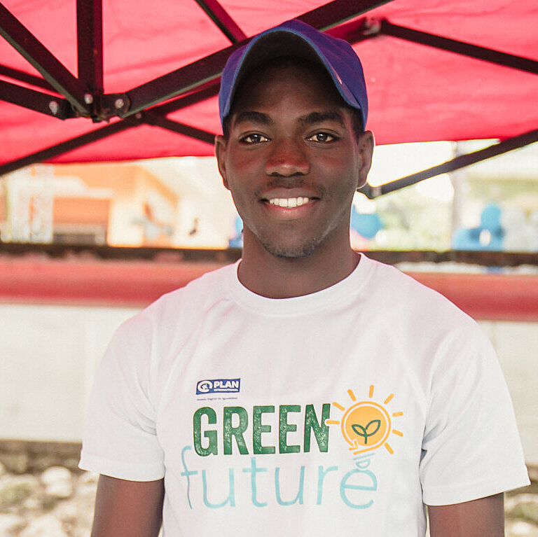 Ein junger Mann steht hinter einem Marktstand mit Schmuckgegenständen
