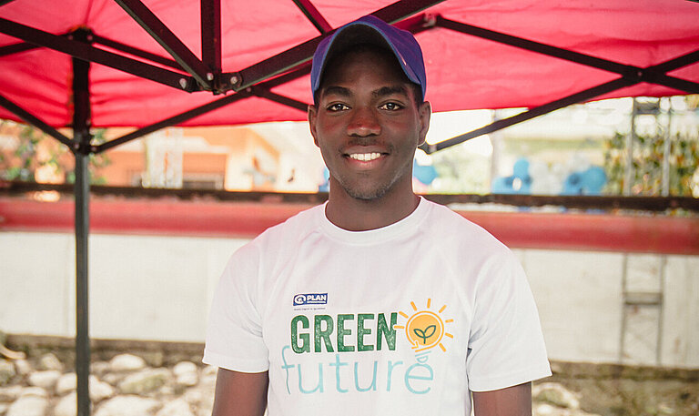 Ein junger Mann steht hinter einem Marktstand mit Schmuckgegenständen