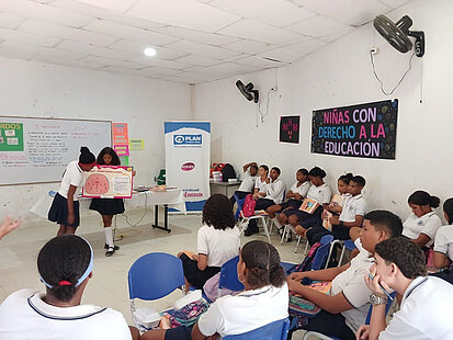 Schulkinder betrachten das Schaubild einer Gebärmutter