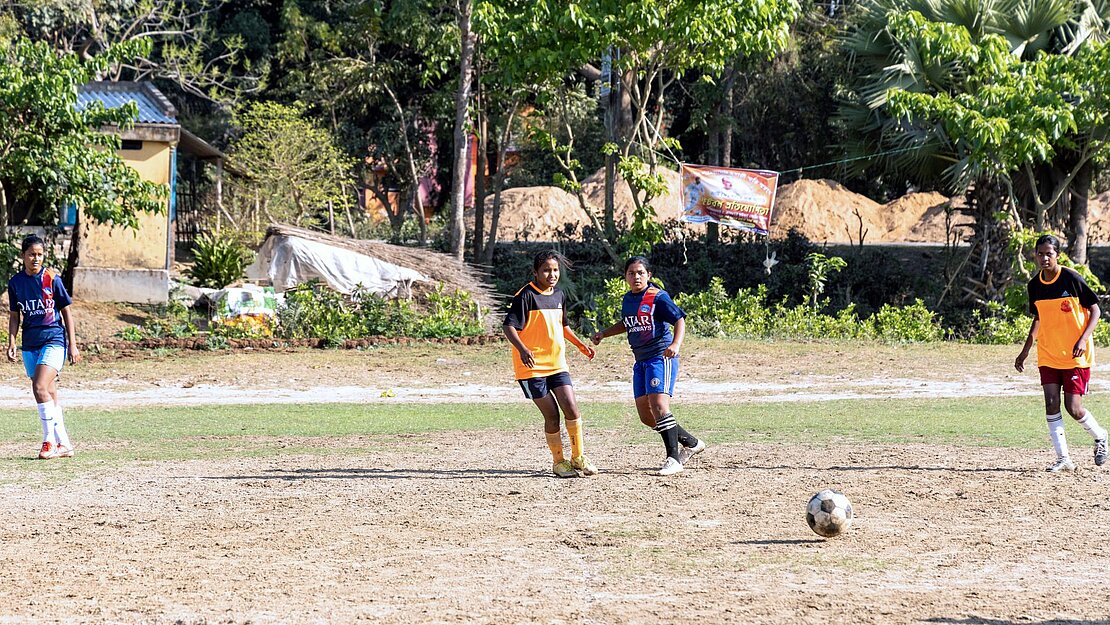 Mädchen spielen auf einem Feld Fußball