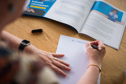 Eine Hand beim Testament schreiben für eine Testamentsspende