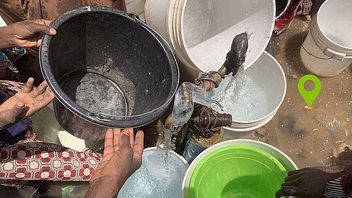 Menschen in Nigeria sammeln Flusswasser in Eimern Menschen sammeln Flusswasser in Plastikeimern