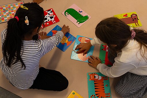 Zwei Mädchen spielen mit Puzzlen