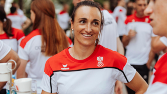 Seglerin Lara Vadlau steht in einer Menge anderer Sportlerinnen und Sportler. Alle tragen ein offizielles Sportshirt für Österreich zu den olympischen Spielen.