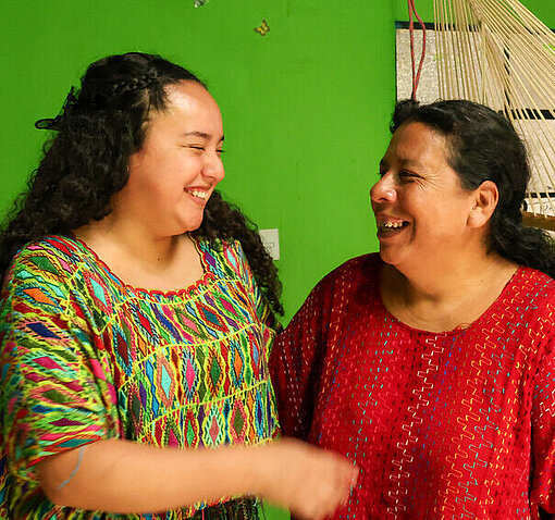 Jaqueline und ihre Mutter Zoila schauen sich an und lächeln einander an