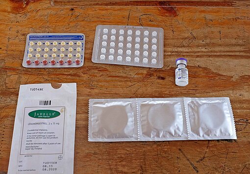 Im Rahmen des Projekts werden Antibabypillen und Kondome ausgegeben Auf einer Tischplatte liegen Verhütungsmittel