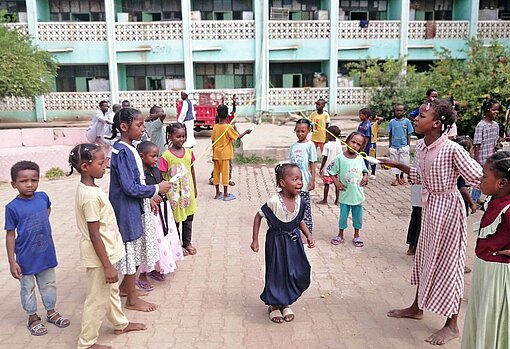 Ein Stück unbeschwerte Kindheit in einem Schutzprojekt für Mädchen und Jungen in Sudan Kinder springen Seil
