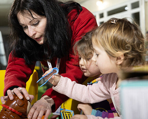 Kinder mit Betreuerin im Lernzentrum Spiele spielend