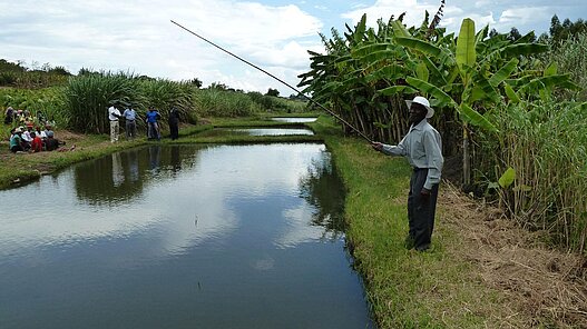 Ein Mann fischt im Teich. Das Bild stammt von einem ähnlichen Plan-Projekt in Simbabwe.