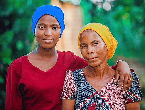 Eine jüngere und eine ältere Frau blicken in die Kamera