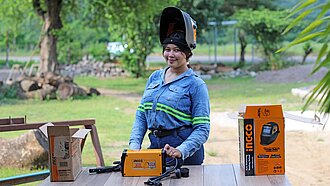 Lizzy mit Helm am Schweißgerät