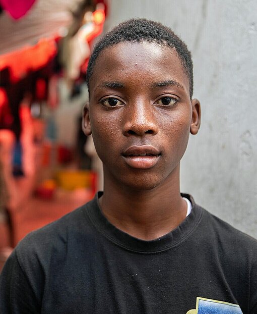 Junior ist eines von 550.000 Kindern, die in Haiti auf der Flucht sind Ein 16-jähriger Junge schaut in die Kamera