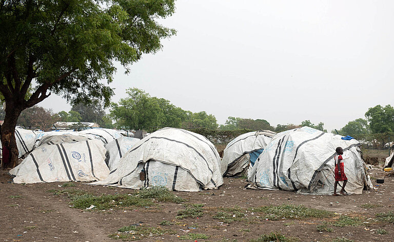 Zelte aus Plastikplanen stehen in einer Steppenlandschaft