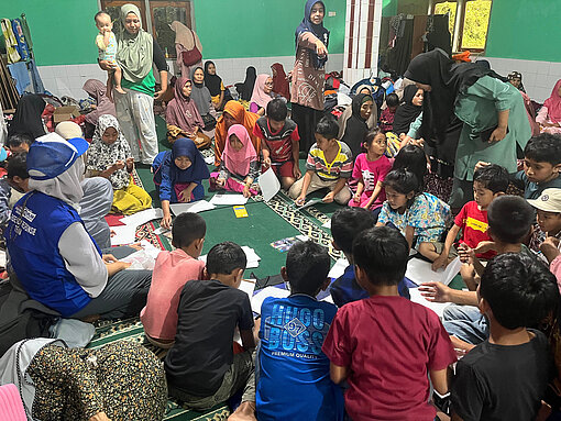 Kinder sitzen im Kreis auf dem Boden