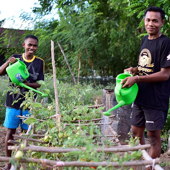 Paul und Taran bewässern Pflanzen 