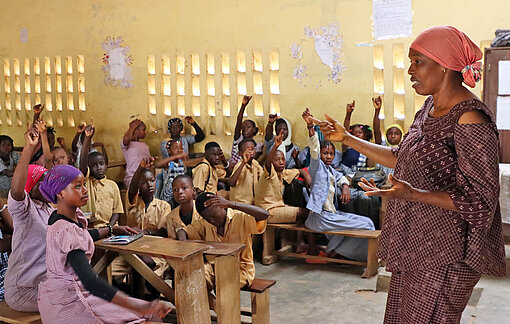 Grundschullehrerin Fanta (re.) spricht mit Kindern über Sex und die Folgen ungewollter Schwangerschaften Eine Frau steht in einem vollen Klassenzimmer und interagiert mit Kindern