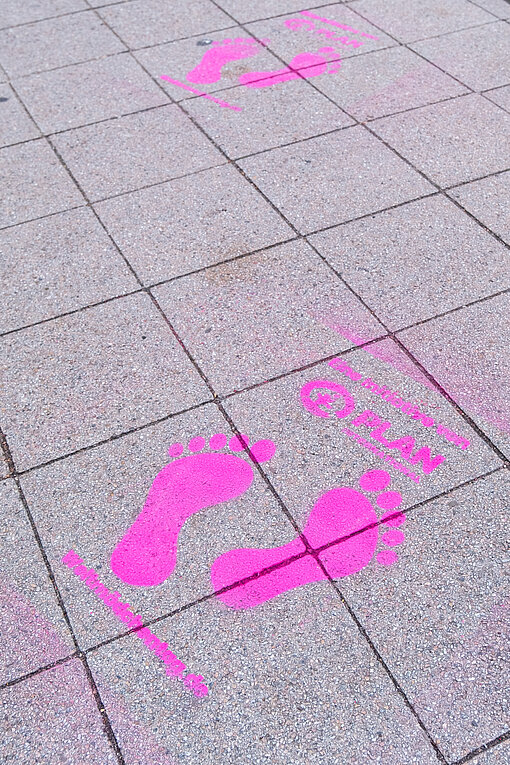 Leuchtend pinke Fußspuren machten am 11. Oktober Hamburger Passant:innen auf den Weltmädchentag aufmerksam Mit pinker Farbe auf den Boden gesprühte Fußspuren