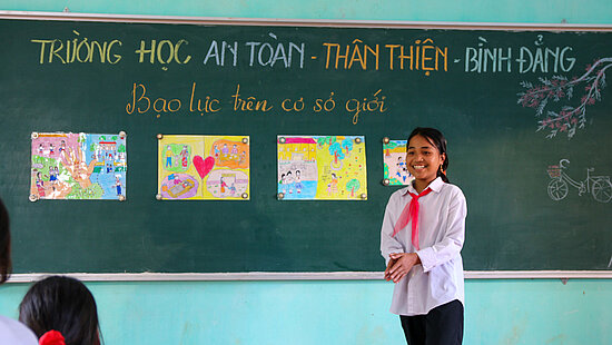 Bild: Eine Schülerin steht an der Tafel und erklärt ihre Zeichnungen
