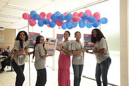 Junge Frauen präsentieren Plakate zu weiblicher Stärke